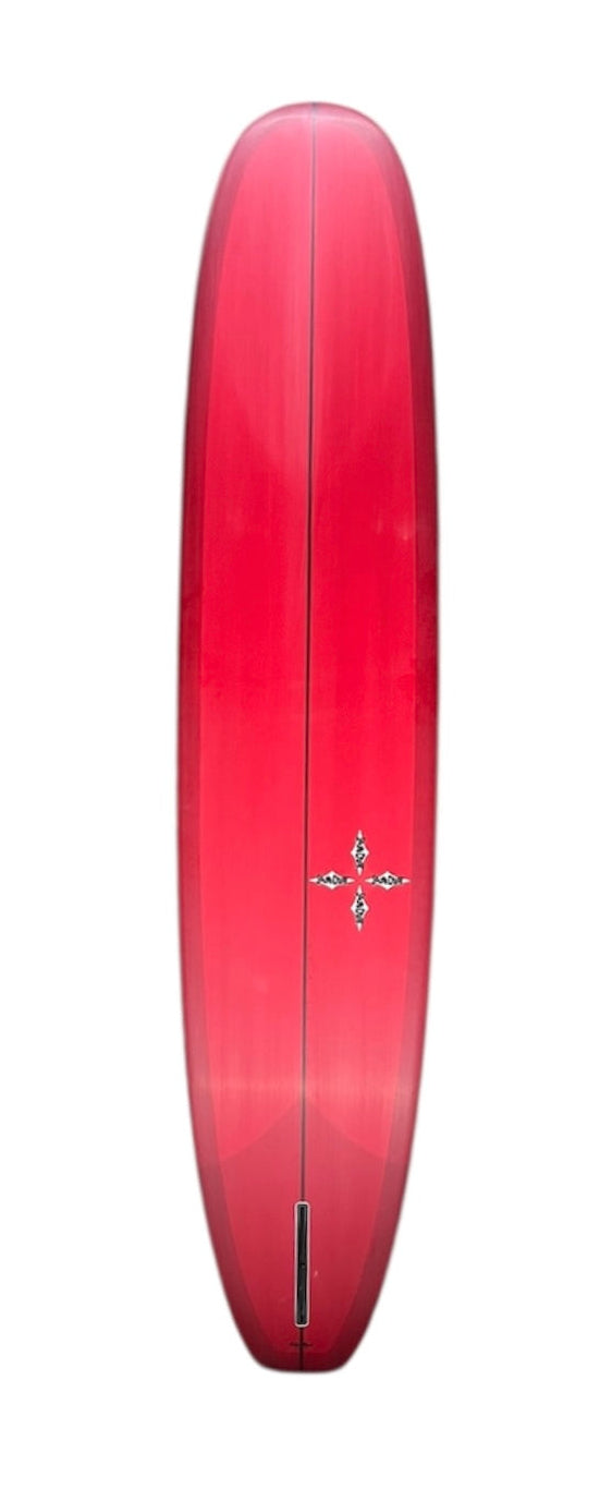 Pink single-fin surfboard, pointed nose and rounded tail, center stringer