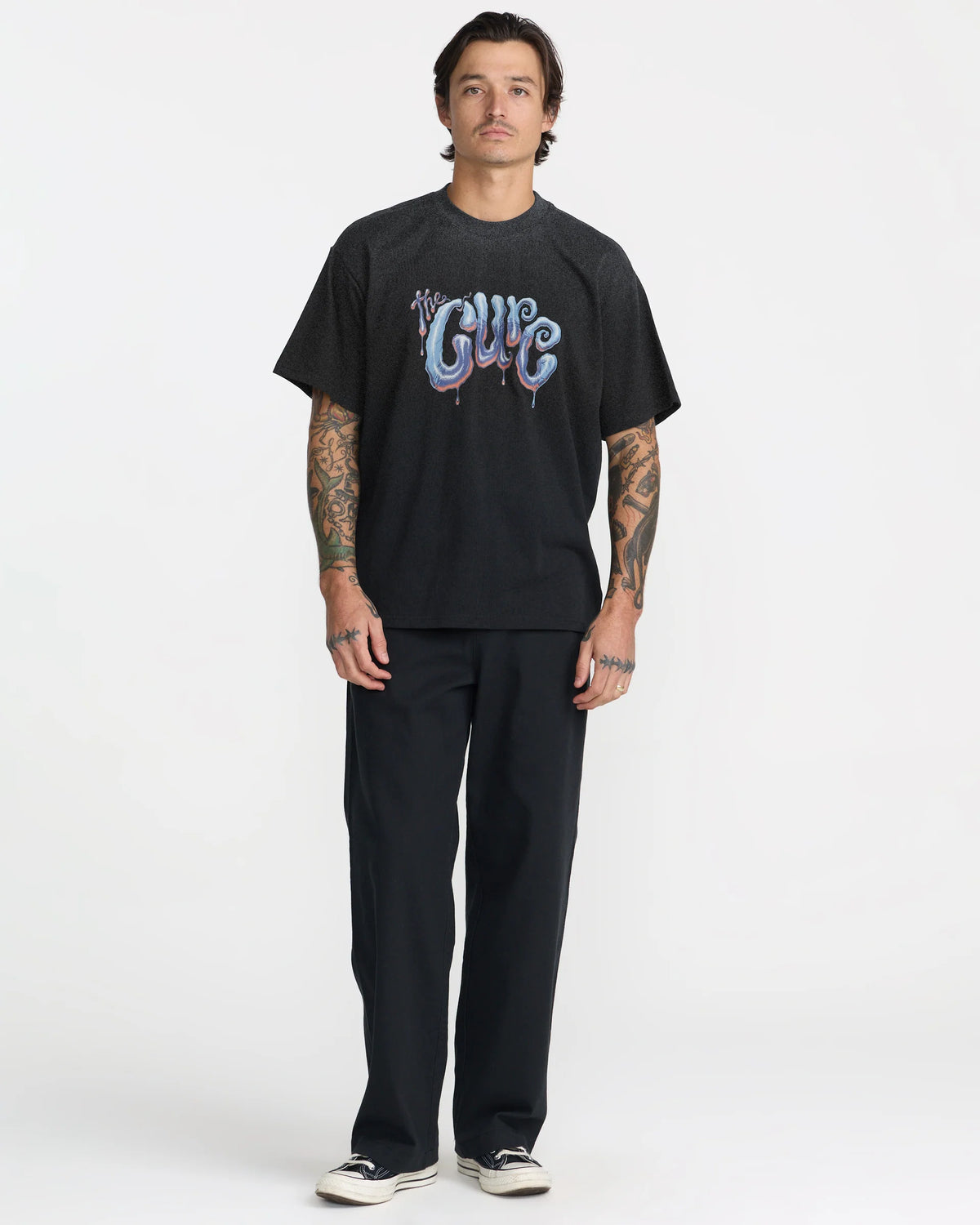 RVCA x The Cure Black Graphic Tee styled with black pants and sneakers, showcasing the relaxed fit, short sleeves, and colorful The Cure front graphic.