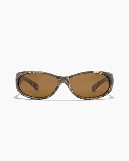 Demon Speed Camo Sunglasses featuring brown tinted lenses, a full camouflage frame, and a sleek wraparound fit, shown from the front.