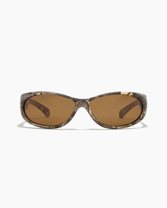 Demon Speed Camo Sunglasses featuring brown tinted lenses, a full camouflage frame, and a sleek wraparound fit, shown from the front.