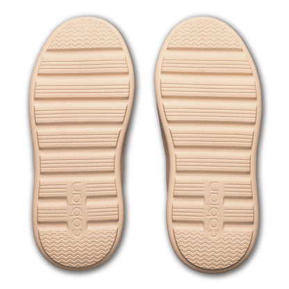Bottom view of Cobian FlipSlip Mauve shoes featuring cream-colored rubber outsoles with textured traction grooves and Cobian branding.