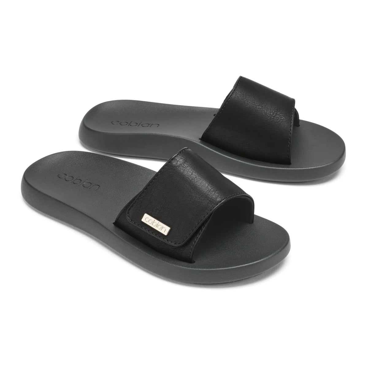 Pair of Cobian Ibiza Slide Sandals in Black featuring wide textured straps, gold logo accents, and contoured footbeds.