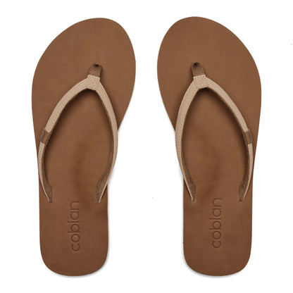 Top view of Cobian Kaia Flip Flops in Cream showing slim V-shaped straps, brown footbeds, and embossed Cobian branding at the heels.
