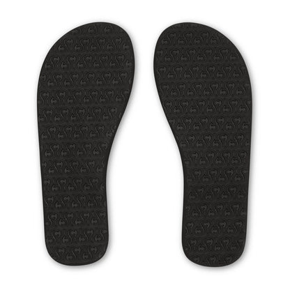 Cobian Nias Bounce 2 black flip flops featuring textured rubber outsoles with a repeating Cobian logo traction pattern.
