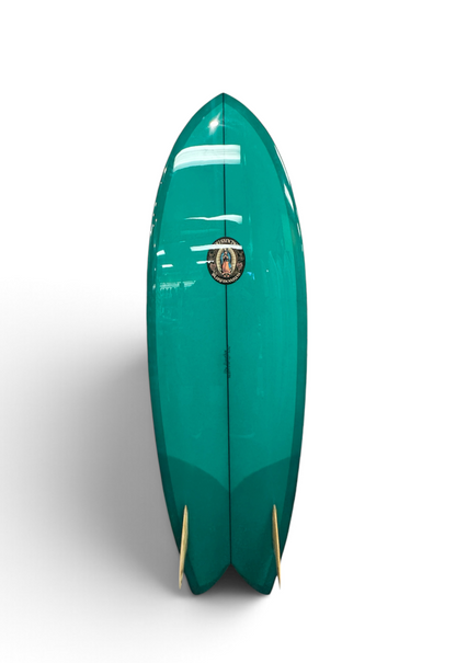 Roy Sanchez 5'10 modern fish surfboard, glossy dark green, glass on twin fins and round nose.