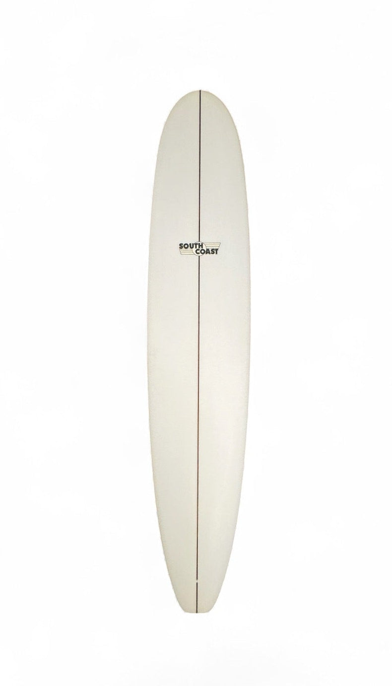 The front of a white South Coast longboard. With a South Coast logo toward the top of the board. 