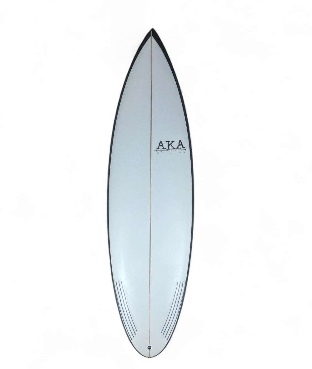 White surfboard with black rails on a white background. 