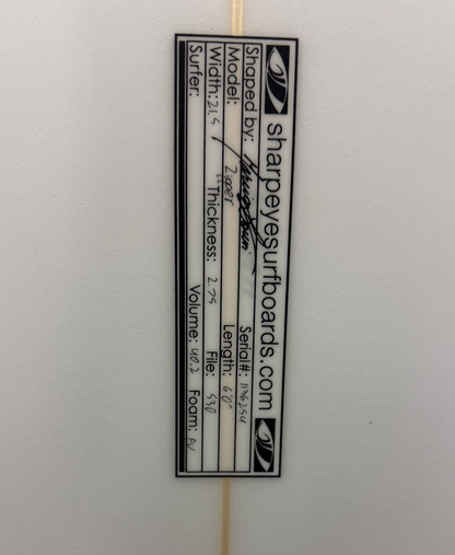 A close up of the dimensions of a white sharpeye surfboard. 