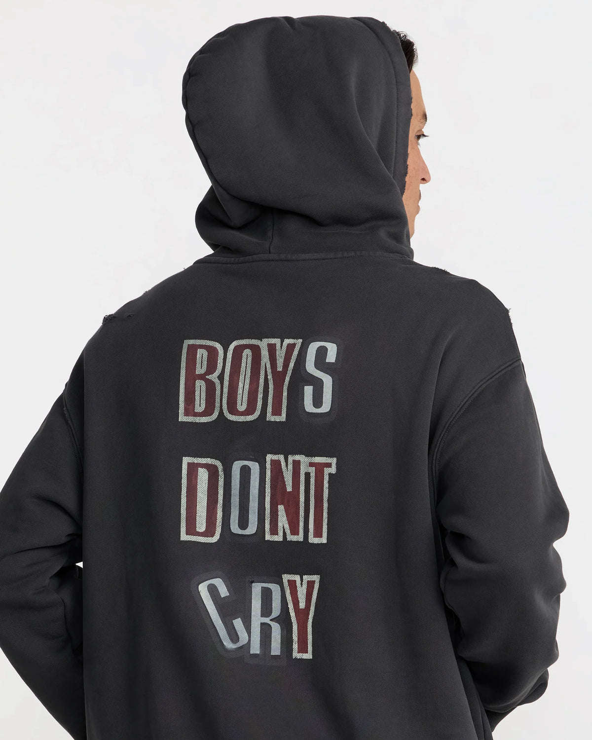 The Cure Boys Don't Cry Hoodie in washed black featuring a large vintage-inspired back graphic with distressed lettering, shown on a model from behind.
