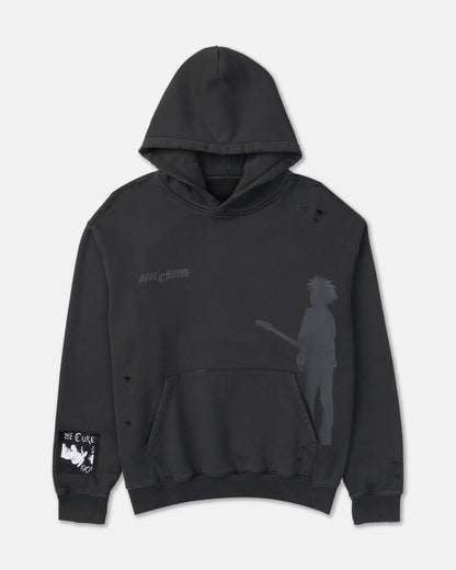 The Cure Hoodie in washed black featuring subtle band graphics, a guitarist silhouette, distressed detailing, kangaroo pocket, and The Cure sleeve patch.