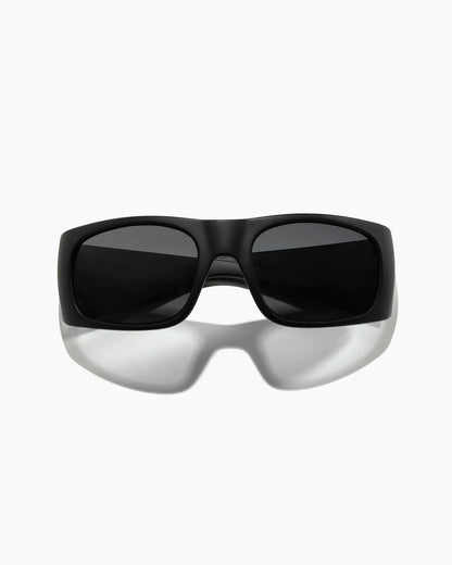 Transmitter by NOA Matte Black Sunglasses featuring dark smoke lenses, a thick rectangular frame, and a sleek wraparound silhouette, shown straight on.